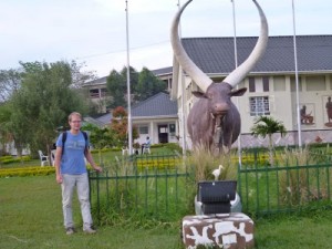 vor dem Ankole-Museum. Dieses Denkmal erinnert an die Bedeutung der Kuh für die Kultur. Konkret erinnert sie an einen Krieg im Jahr 1740, der ausgebrochen ist, nachdem ein König eine besonders schöne Kuh eines anderen Stammes stehlen lassen hat, weil man ihm sie nicht verkaufen wollte. 4000 Tote